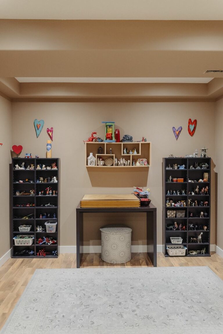 A room with a desk, shelves, and shoe racks.
